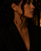 Profile view of gold sword threader earring with ruby briolette hanging from blade tip, showing 75mm drop length.